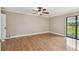 Large bedroom featuring hardwood floors, a ceiling fan, and a sliding glass door to the outside at 4946 Mill Pond Rd # 3180, Wesley Chapel, FL 33543