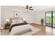 Well-lit main bedroom with balcony, light wood floors, a ceiling fan, and bedside tables at 4946 Mill Pond Rd # 3180, Wesley Chapel, FL 33543