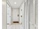 Bright hallway featuring white shaker doors and trim with neutral walls and tile flooring at 4946 Mill Pond Rd # 3180, Wesley Chapel, FL 33543