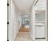 Neutral hallway leading to bright living space; view of open kitchen with tile floors and white appliances at 4946 Mill Pond Rd # 3180, Wesley Chapel, FL 33543