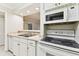 Open kitchen layout showcasing stainless sink and updated appliance, flowing seamlessly to the dining room at 4946 Mill Pond Rd # 3180, Wesley Chapel, FL 33543