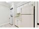 Bright white kitchen with stainless appliances and a laundry area conveniently located with the refrigerator at 4946 Mill Pond Rd # 3180, Wesley Chapel, FL 33543