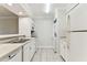 A clean and bright white kitchen featuring stainless steel appliances and a stackable washer/dryer at 4946 Mill Pond Rd # 3180, Wesley Chapel, FL 33543