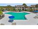 Community pool with sun loungers and umbrellas, surrounded by lush landscaping at 4946 Mill Pond Rd # 3180, Wesley Chapel, FL 33543