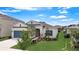 A single-story home exhibiting a well-maintained lawn, blue shutters, and a welcoming front entrance, under blue skies at 5521 Limelight Dr, Apollo Beach, FL 33572