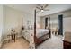 Relaxing main bedroom with four-poster bed, ceiling fan, carpeted floors, and natural light from the windows at 5521 Limelight Dr, Apollo Beach, FL 33572
