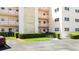 Image features the entryway to the building and a well manicured landscape at 5623 80Th N St # 202, St Petersburg, FL 33709