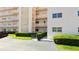 Image features the entryway to the building and a well manicured landscape at 5623 80Th N St # 202, St Petersburg, FL 33709