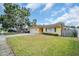 A charming yellow home with a well-kept lawn, complemented by a large shade tree enhancing its curb appeal at 5920 Denver Ne St, St Petersburg, FL 33703
