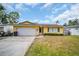 Charming single-story home with a front yard, white garage door, and classic design at 5920 Denver Ne St, St Petersburg, FL 33703