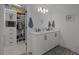 Bright bathroom featuring dual sinks, modern fixtures, and a nearby walk-in closet for added convenience at 710 W River Heights Ave, Tampa, FL 33603