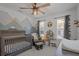 Inviting Bedroom featuring a crib, glider, and mountain mural creating a playful and cozy atmosphere at 710 W River Heights Ave, Tampa, FL 33603