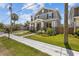 Inviting two-story home featuring a cozy front porch, vibrant landscaping, and sidewalk access at 710 W River Heights Ave, Tampa, FL 33603