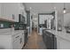 Modern kitchen boasts stainless steel appliances, white cabinets, and an open layout with wood-look flooring at 710 W River Heights Ave, Tampa, FL 33603
