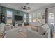 Comfortable living room with large windows, neutral tones, a decorative fan, and a cozy fireplace at 710 W River Heights Ave, Tampa, FL 33603