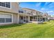 Backyard view showing a lush lawn and a screened lanai, perfect for relaxing outdoors and entertaining guests at 732 Kensington Lake Cir, Brandon, FL 33511