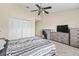 Bedroom with ceiling fan, carpet, and bed with black and white patterned covers at 732 Kensington Lake Cir, Brandon, FL 33511