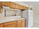 Kitchen featuring a pass-through to another room, white appliances, and neutral countertop at 732 Kensington Lake Cir, Brandon, FL 33511