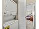This laundry area features a stacked washer and dryer, with a glimpse into the bedroom through the doorway at 732 Kensington Lake Cir, Brandon, FL 33511