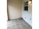 Cozy patio area featuring neutral tile flooring, a window with white trim, and a wall-mounted light fixture at 732 Kensington Lake Cir, Brandon, FL 33511