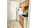 Kitchen features white appliances, double basin sink, and natural wood cabinetry at 7506 Presley Pl # 107, Tampa, FL 33617