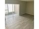 Living room with wood-look flooring and sliding glass door for natural light and access to balcony at 7506 Presley Pl # 107, Tampa, FL 33617