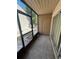 Enclosed patio featuring weathered flooring, screening, and a door leading to additional storage at 7506 Presley Pl # 107, Tampa, FL 33617