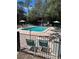Community pool surrounded by lounge chairs and greenery, fenced in for safety and privacy at 7506 Presley Pl # 107, Tampa, FL 33617