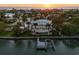 Sunset aerial view of a grand waterfront estate featuring a private dock and swimming pool at 755 Bay Esplanade, Clearwater Beach, FL 33767