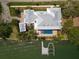 Aerial view of a stunning home with a private pool, dock, and beautifully landscaped grounds near the water at 755 Bay Esplanade, Clearwater Beach, FL 33767