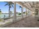 Waterfront balcony framed by stately columns with views of the pool and boat docks at 755 Bay Esplanade, Clearwater Beach, FL 33767