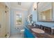 Bright bathroom featuring a shower, granite countertop, sink, and a shuttered window at 755 Bay Esplanade, Clearwater Beach, FL 33767