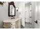 Elegant half-bathroom featuring decorative mirror and sconces and marble countertop at 755 Bay Esplanade, Clearwater Beach, FL 33767