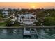 Stunning waterfront home with dock, pool, and lush landscaping at sunset at 755 Bay Esplanade, Clearwater Beach, FL 33767