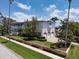 Landscaped property showcasing a three-car garage, lush lawn, and a sidewalk running alongside the street at 755 Bay Esplanade, Clearwater Beach, FL 33767