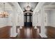 Grand foyer with striking dark wood floors, elegant white columns, and a modern chandelier at 755 Bay Esplanade, Clearwater Beach, FL 33767