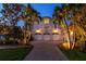 A three-car garage with lit landscaping, located on a tree-lined drive at 755 Bay Esplanade, Clearwater Beach, FL 33767