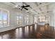Bright living room with water view, coffered ceiling, dark wood floors and arched doorways leading to the kitchen at 755 Bay Esplanade, Clearwater Beach, FL 33767