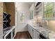 Butler's pantry area with marble countertops, cabinetry, and a wine fridge at 755 Bay Esplanade, Clearwater Beach, FL 33767