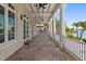Expansive covered patio with tiled floors, white pillars, and views of the water at 755 Bay Esplanade, Clearwater Beach, FL 33767