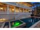 Backyard pool with adjoining spa featuring travertine tile surround and views of the rear of the house at 755 Bay Esplanade, Clearwater Beach, FL 33767