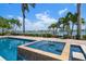 Stunning pool and spa combo overlooking the serene waterfront, framed by palm trees, offering the perfect retreat at 755 Bay Esplanade, Clearwater Beach, FL 33767