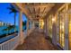 Outdoor terrace featuring a covered porch with pillars, ceiling fans, and water views at 755 Bay Esplanade, Clearwater Beach, FL 33767