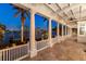 A column-lined outdoor porch with tile flooring and waterfront views; the perfect place to relax at 755 Bay Esplanade, Clearwater Beach, FL 33767