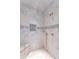 Modern shower featuring elegant marble tiling and brass fixtures at 755 Bay Esplanade, Clearwater Beach, FL 33767