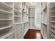 Spacious walk-in closet featuring custom shelving, cabinets, drawers, and hardwood floors at 755 Bay Esplanade, Clearwater Beach, FL 33767