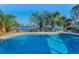 Inviting swimming pool surrounded by lush palm trees and views of the open waterway at 795 116Th Ave, Treasure Island, FL 33706
