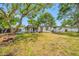 Large backyard with mature trees and a covered patio, offering ample space for outdoor activities and relaxation at 8444 8Th N Way, St Petersburg, FL 33702