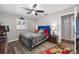 Cozy bedroom featuring a ceiling fan, wood floors, and a comfortable queen-sized bed at 8444 8Th N Way, St Petersburg, FL 33702