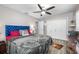 Bedroom with ceiling fan, wood floors, white closet doors and blue upholstered headboard at 8444 8Th N Way, St Petersburg, FL 33702